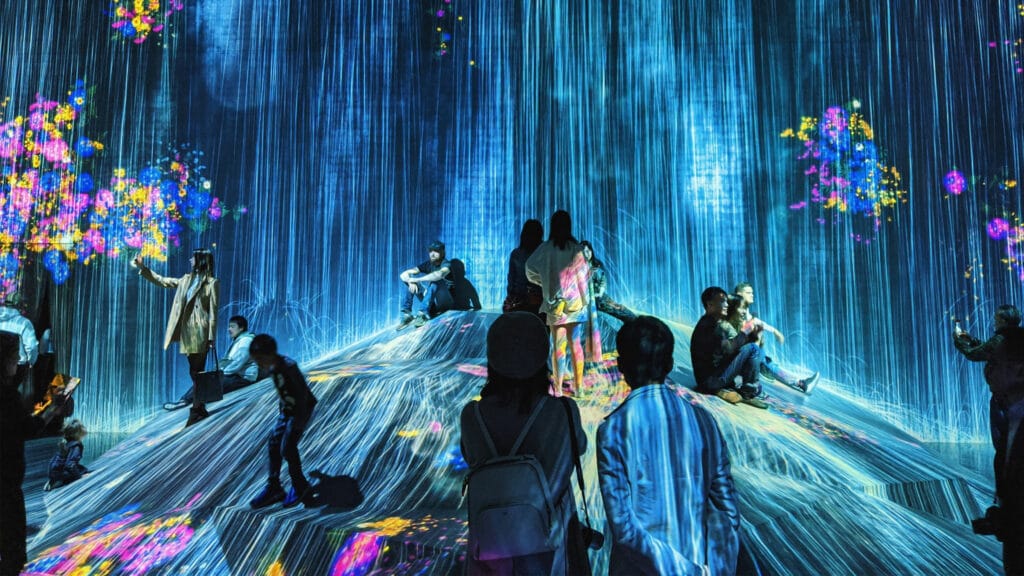 Menschengruppe in einer futuristisch anmutenden, digitalen Ausstellung.
